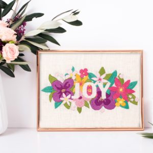 Buntes Blumenbild mit dem Wort Joy sticken | Stickpackung über Zur Lila Pampelmuse